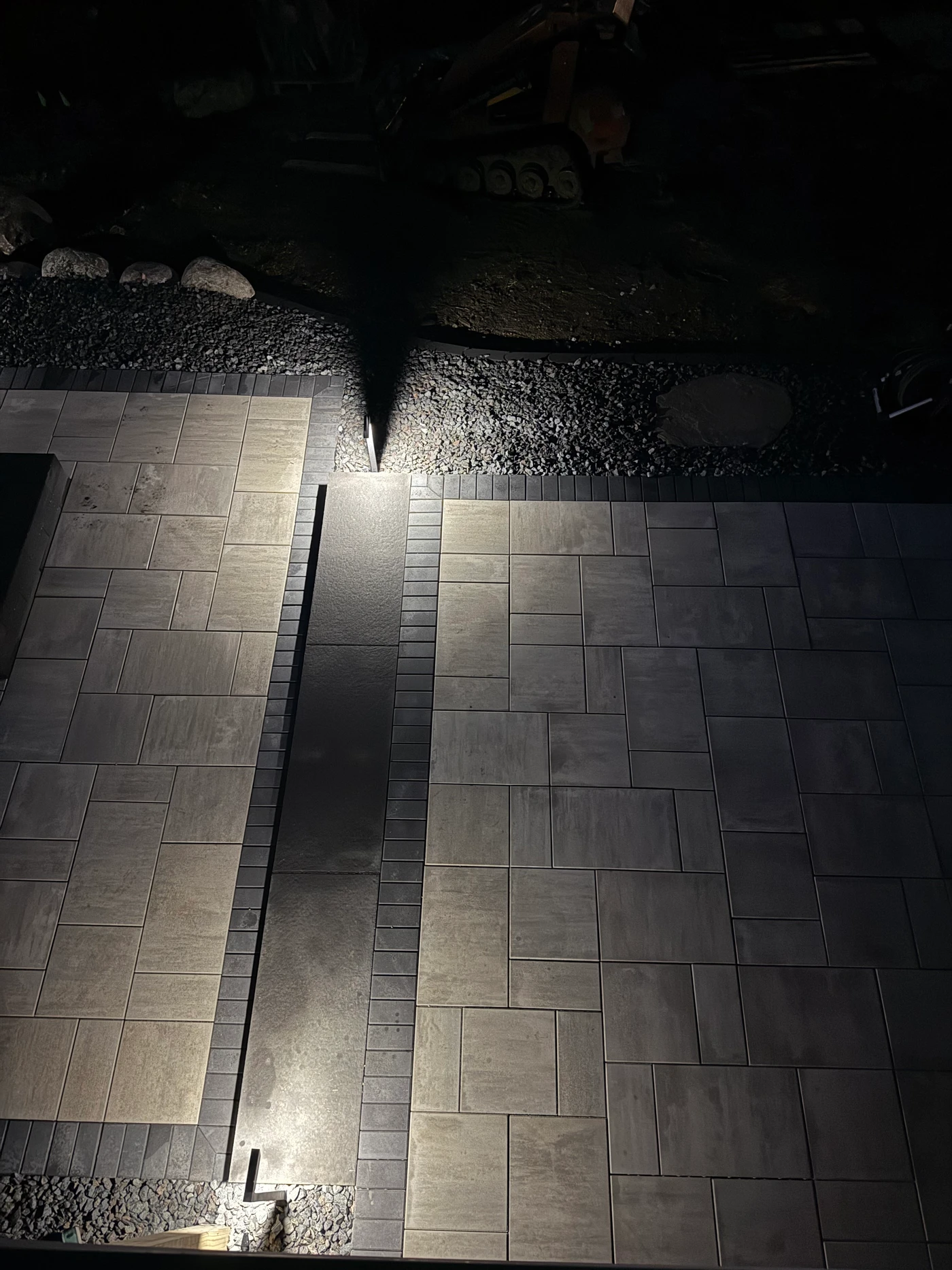 Lifecycle path lights illuminating the borders of a paver walkway and patio at night