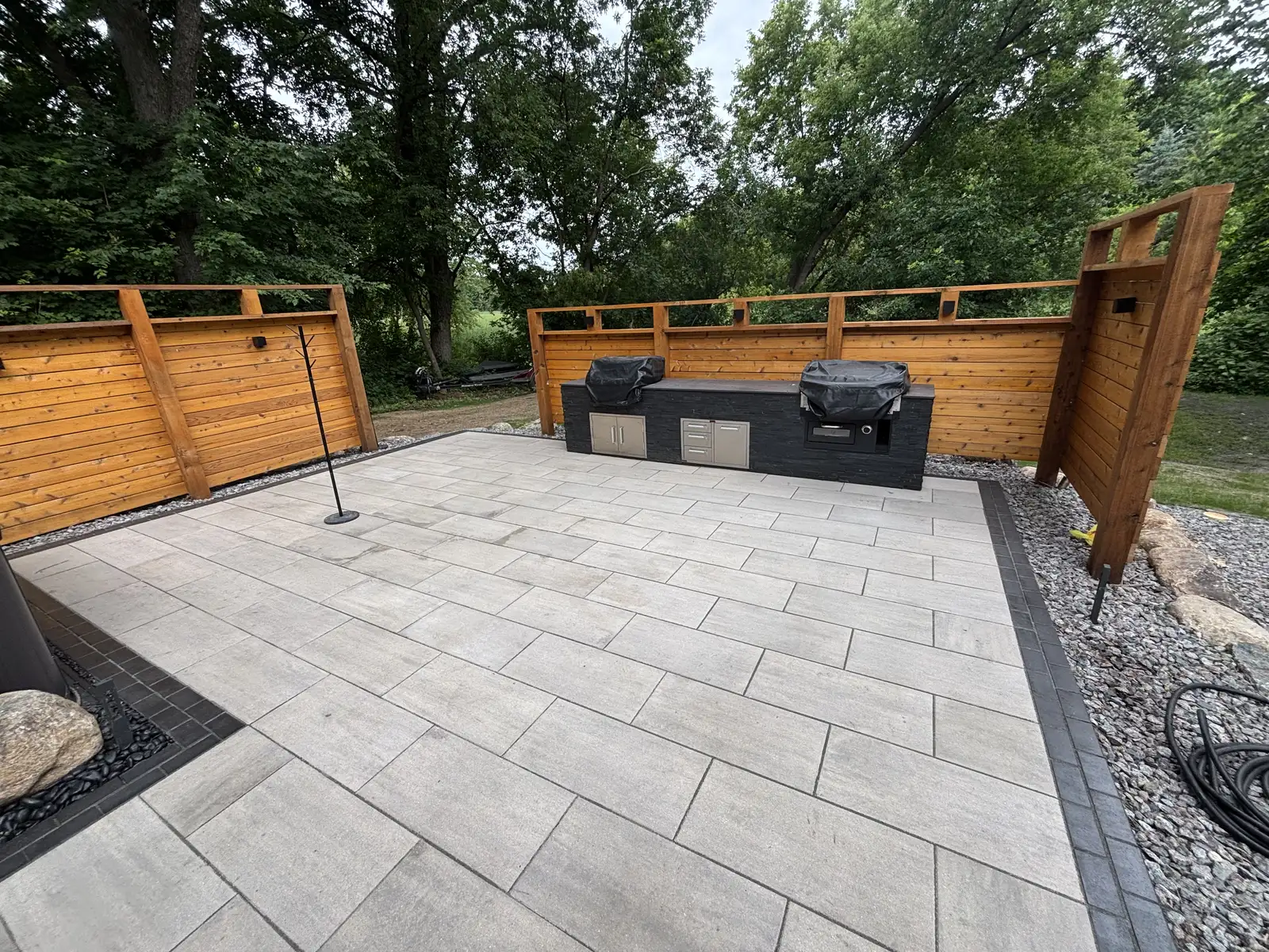 Completed patio, outdoor kitchen and cedar privacy screening by Lifecycle Outdoor Services