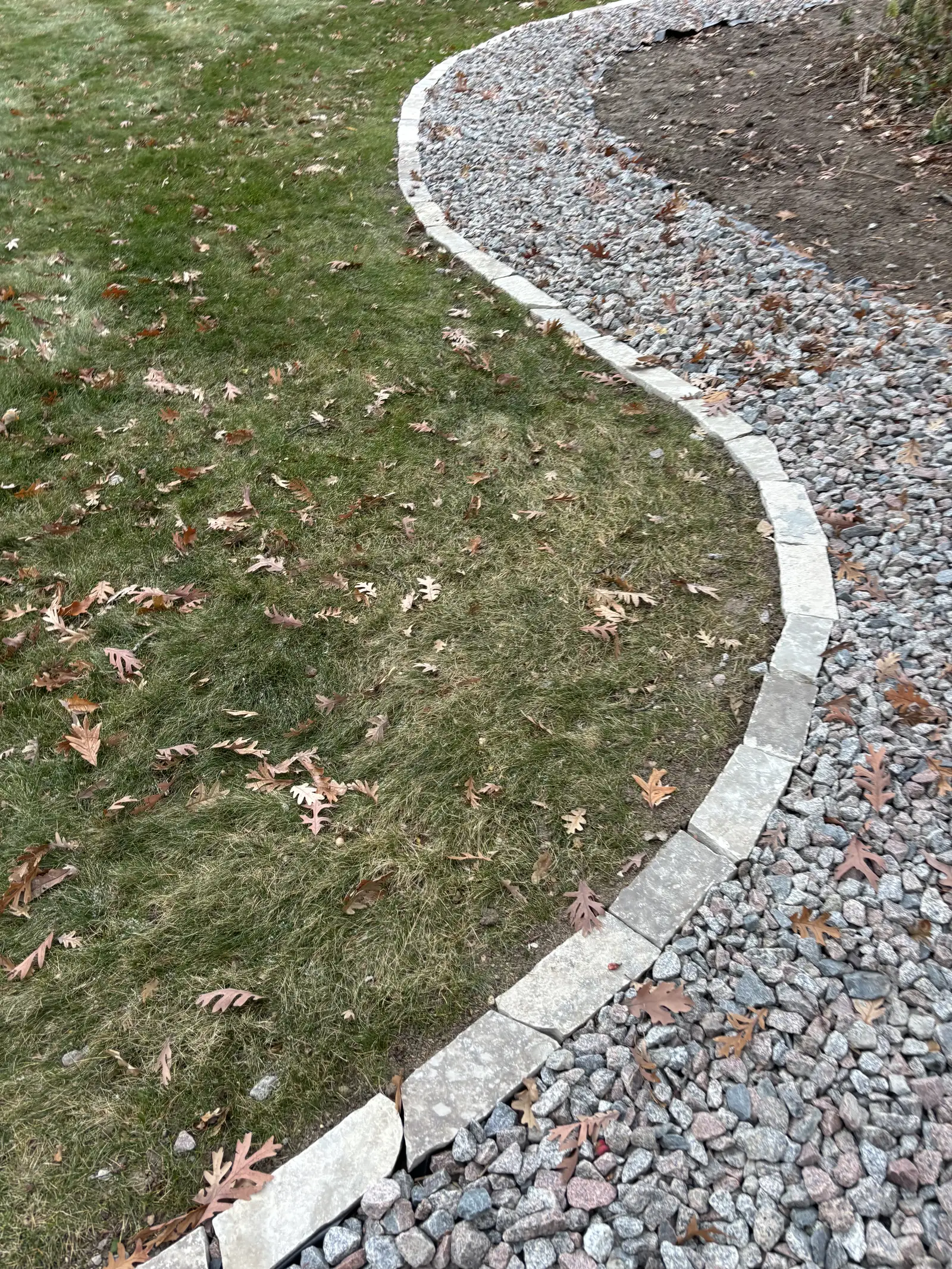 Natural stone outdoor fireplace with seating area and landscape lighting