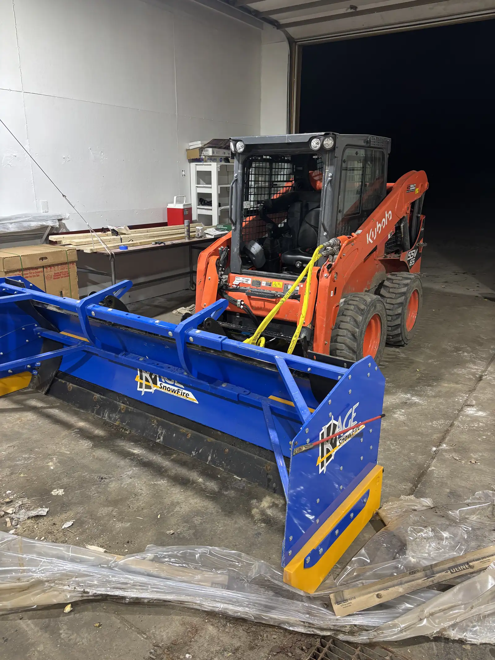 Kubota skid steer equipped with KAGE SnowFire commercial snow plow blade in Lifecycle shop