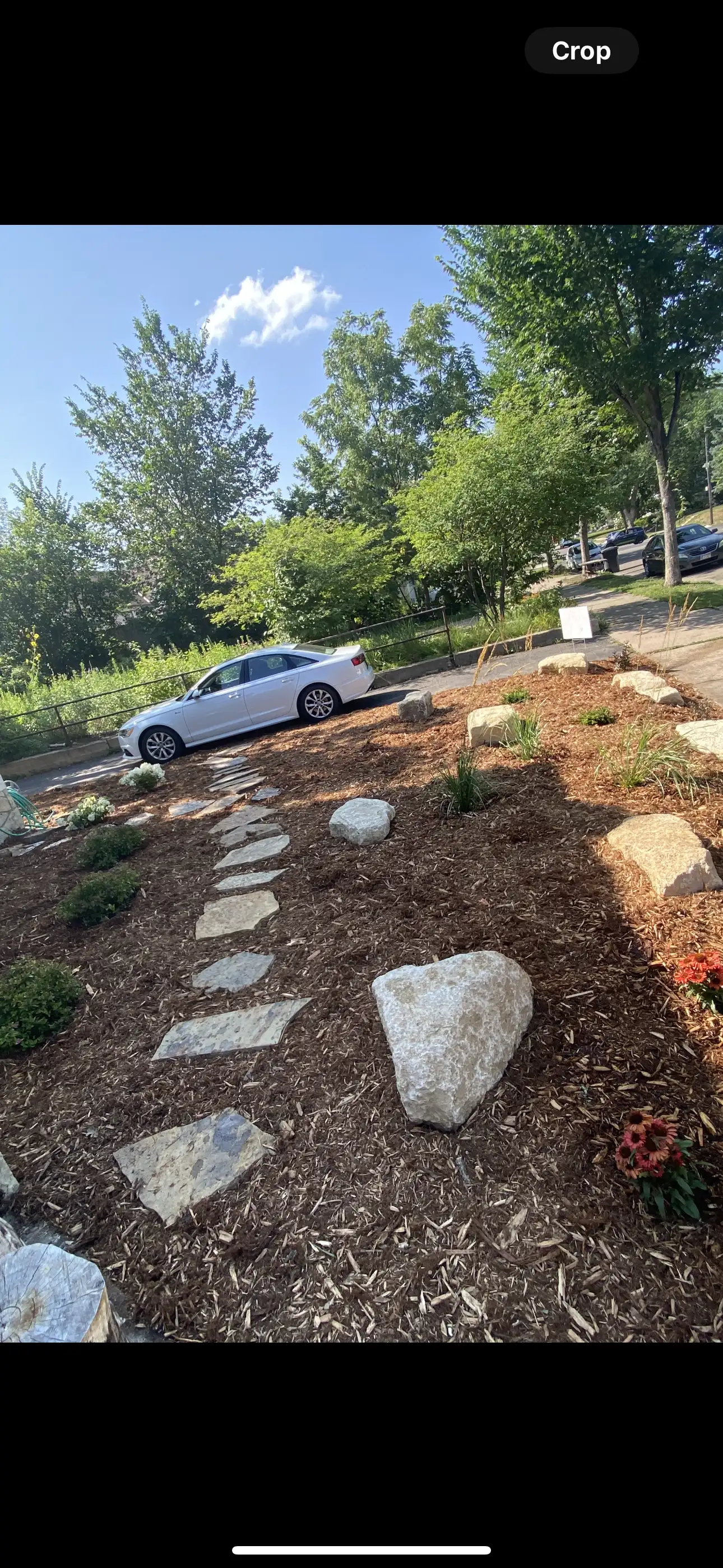 Round stone fire pit with gas flame and fire glass on a residential patio