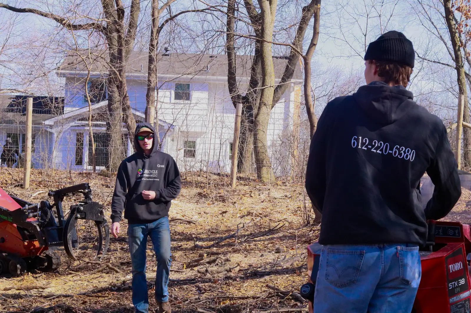 Lifecycle Outdoor Services crew members in branded hoodies on a residential jobsite