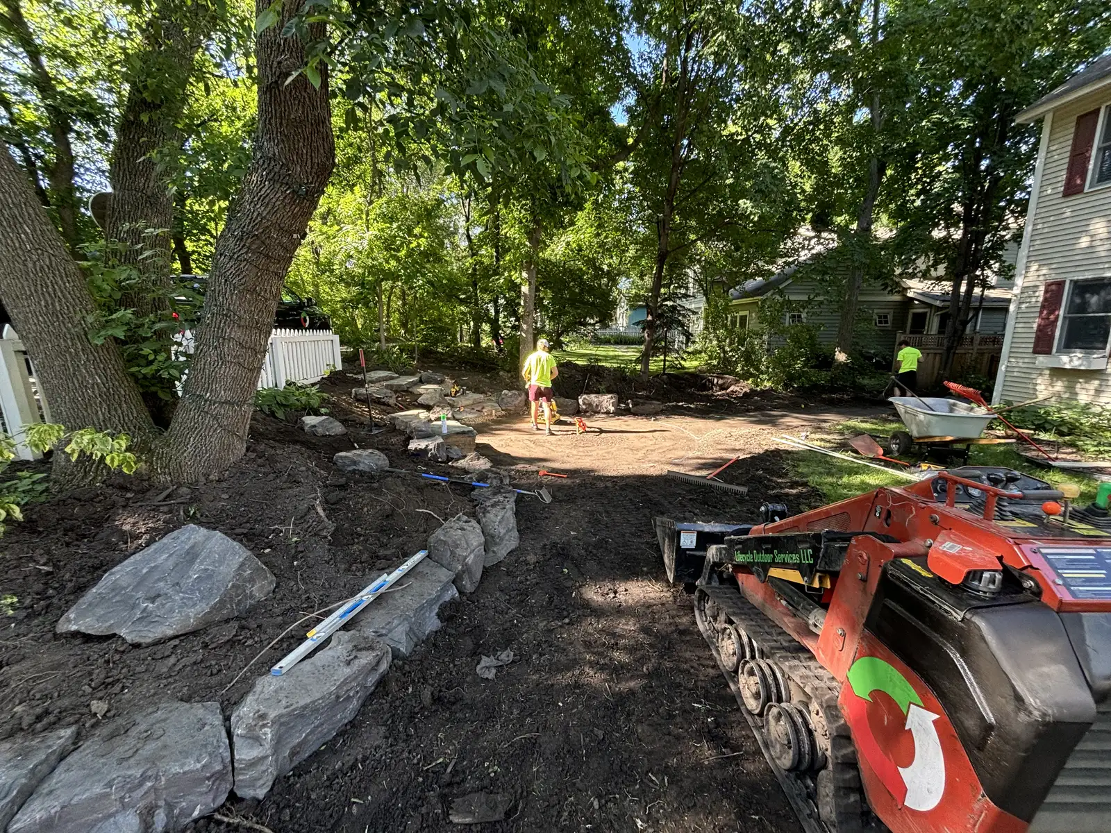 Natural stone walkway and planting beds surrounding flagstone patio