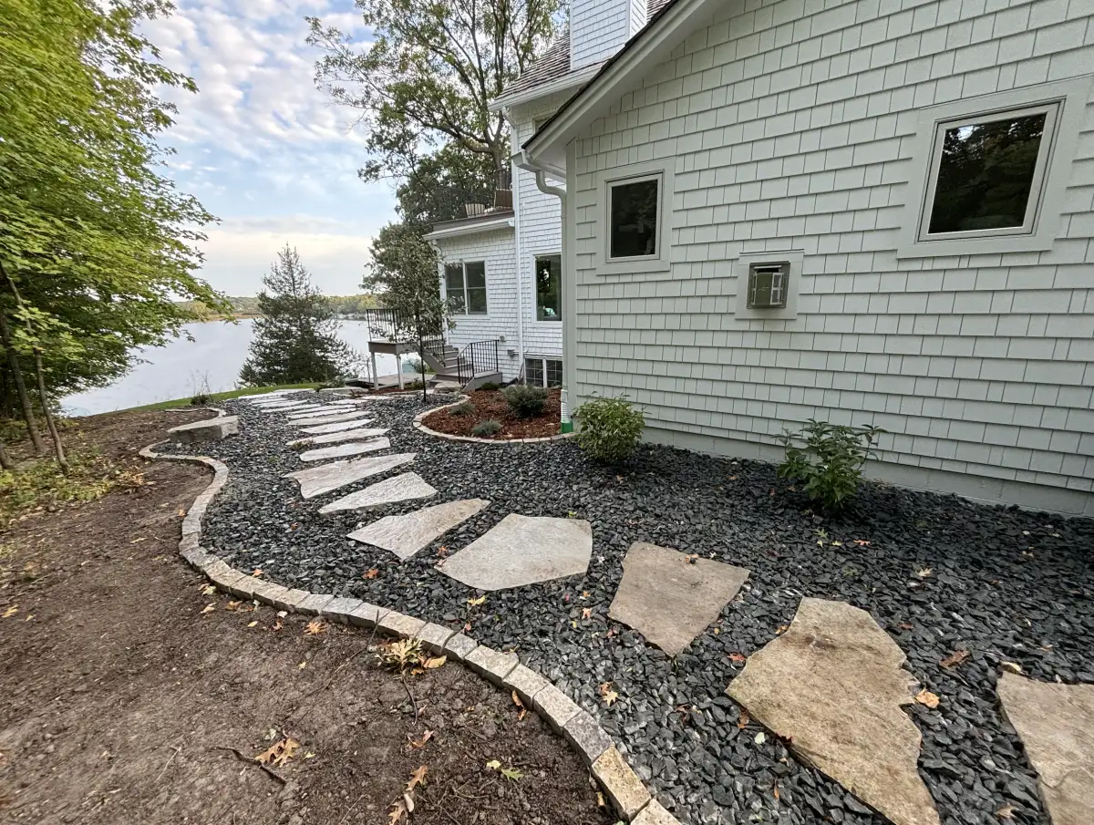 Completed natural stone stepping path with trap rock and Fond du Lac edging along side of lakefront home in Orono, MN