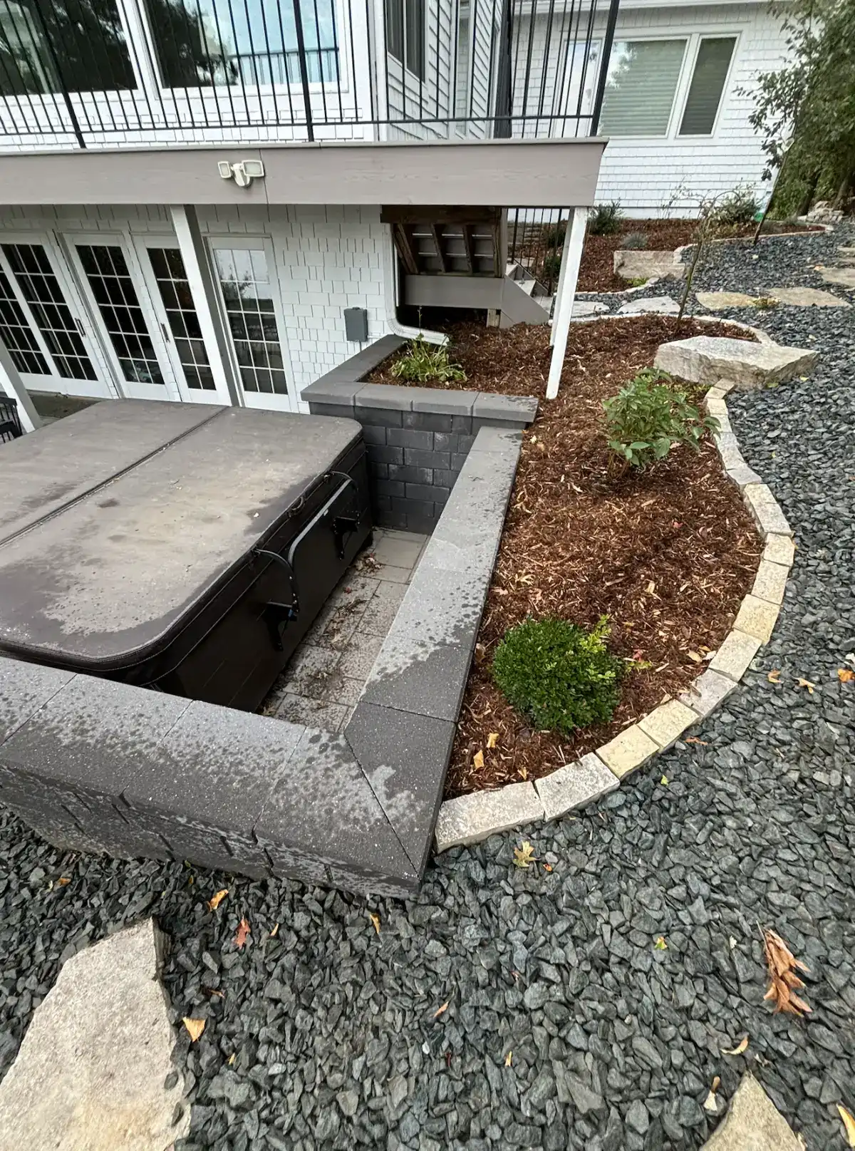 Hot tub area with cedar mulch beds, new plantings, and Fond du Lac stone edging at lakefront property in Orono, MN