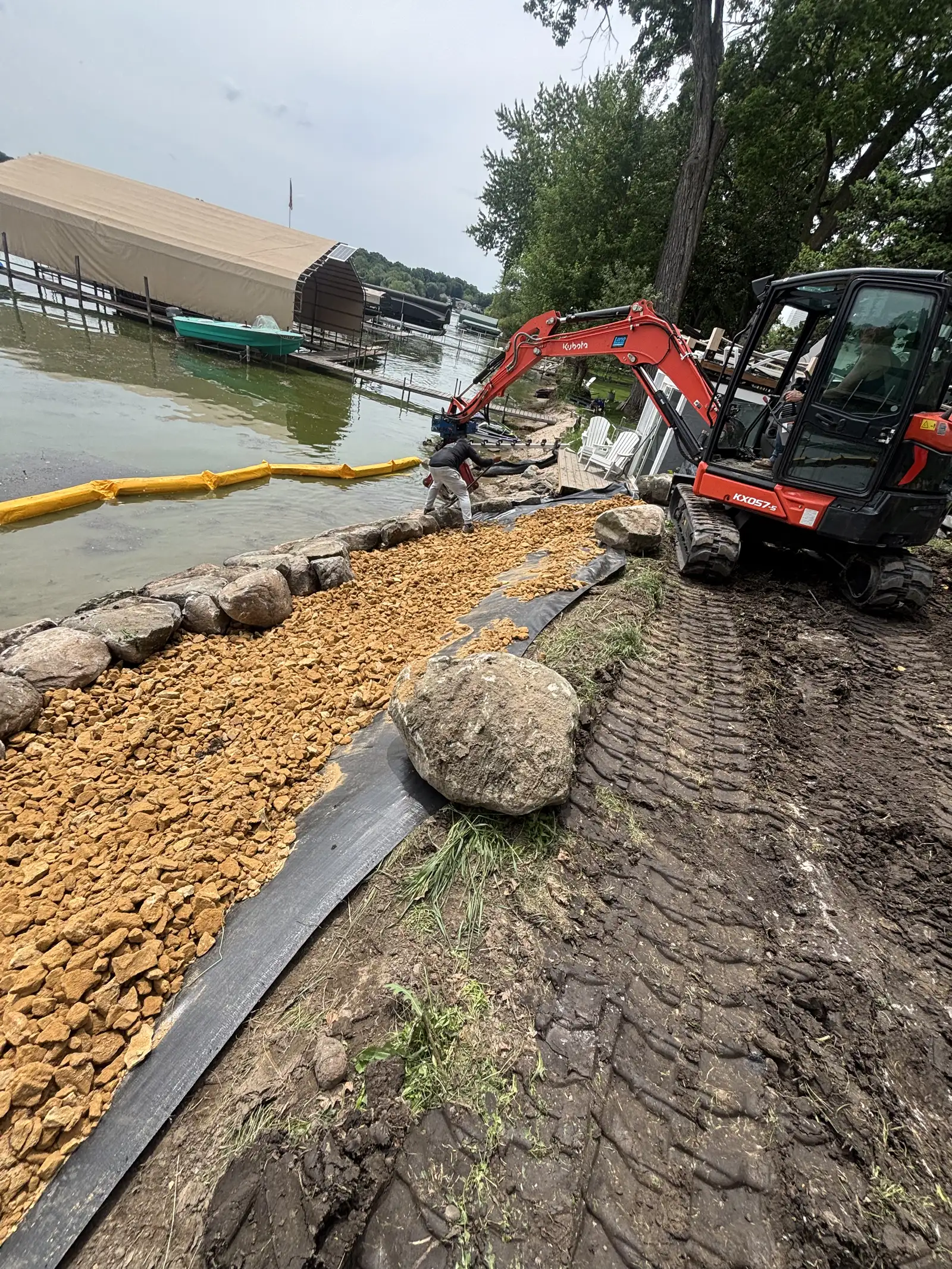 Large fieldstone boulders being placed for lakeshore riprap rebuild in Orono, MN