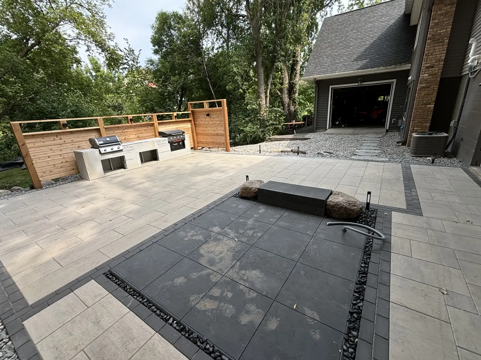 Cedar privacy screening and paver patio with hot tub at outdoor living space in Waconia, MN